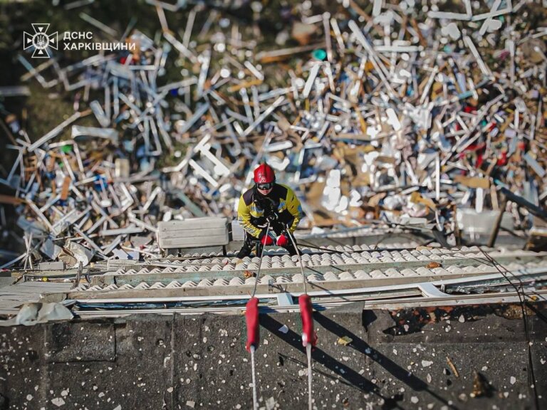 На фото – рятувальник піднімається по уламках даху зруйнованої будівлі у Харкові